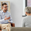Eine ältere Frau im Gespräch mit einem Psychotherapeuten