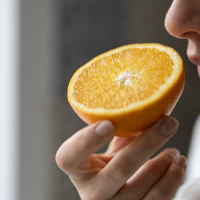 Frau riecht an Orange
