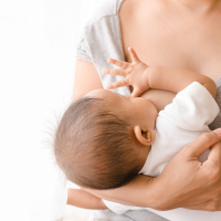 Säugling trinkt an Brust