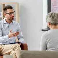 Eine ältere Frau im Gespräch mit einem Psychotherapeuten