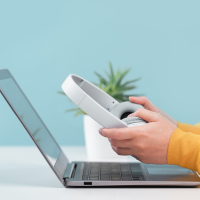 Webinar-Illustration: Hände mit Kopfhörer über Laptop