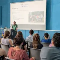 Jörg Meerpohl steht beim Methodenforum am Rednerpult und hält einen Vortrag, im Vordergrund sitzen Konferenzteilnehmende