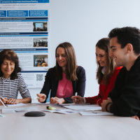 Menschen sitzen um einen Tisch